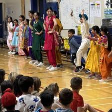 Students dressed in traditional attire to celebrate Diwali perform at school assembly